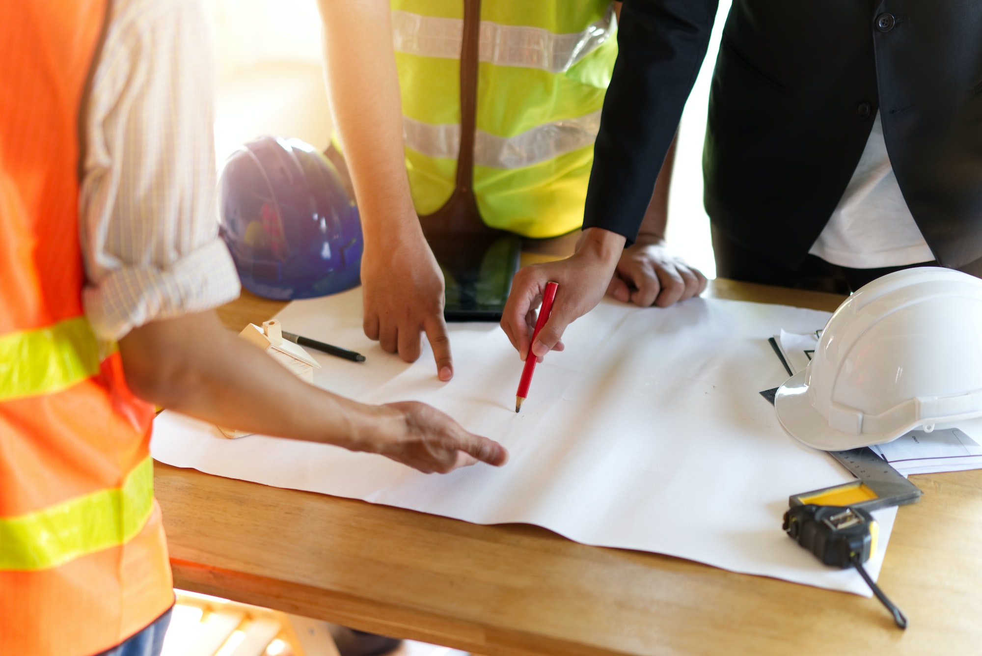 Close up view of group of home building members gathering on working table.