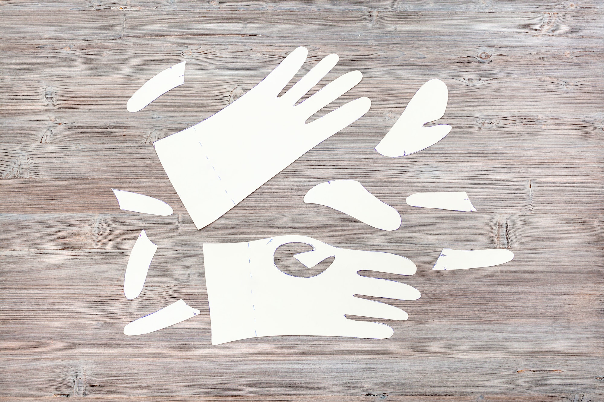 paper templates of gloves on wooden table